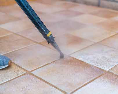 Steam grout cleaning tool treating tile floor grout in Tucson home